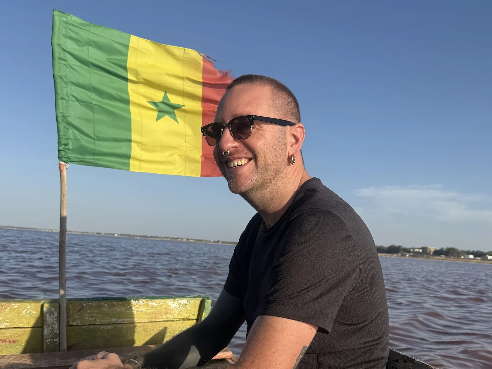 François Aubinet en pirogue, sous un drapeau du Sénégal