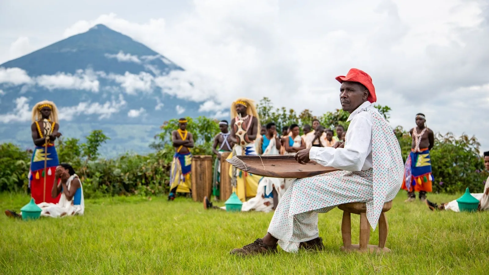 Musicien et danseurs traditionnels devant un volcan des Virunga, lors d’une mission au Rwanda en 2018